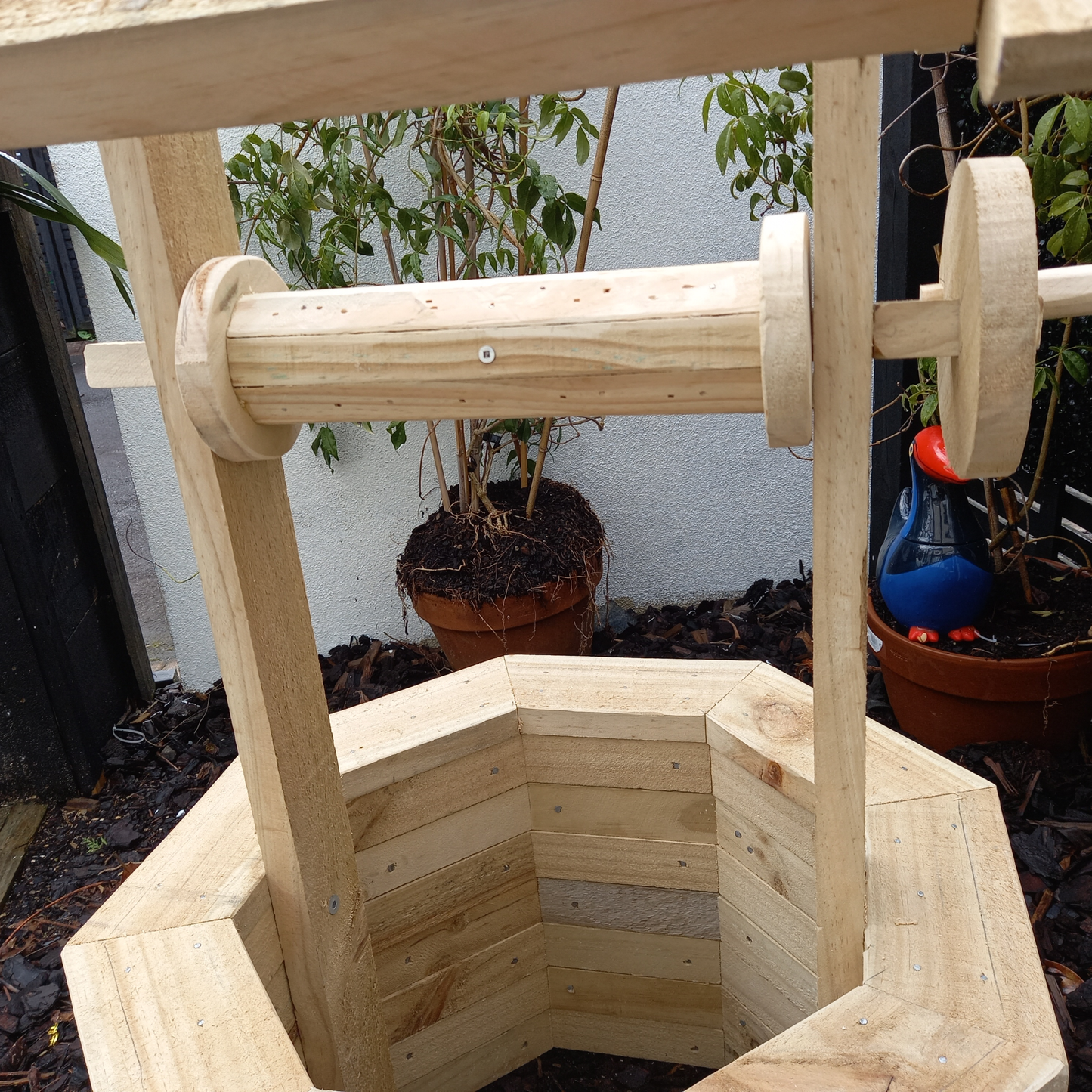 DIY plans to build a wood-brick wishing well with a brushwood roof